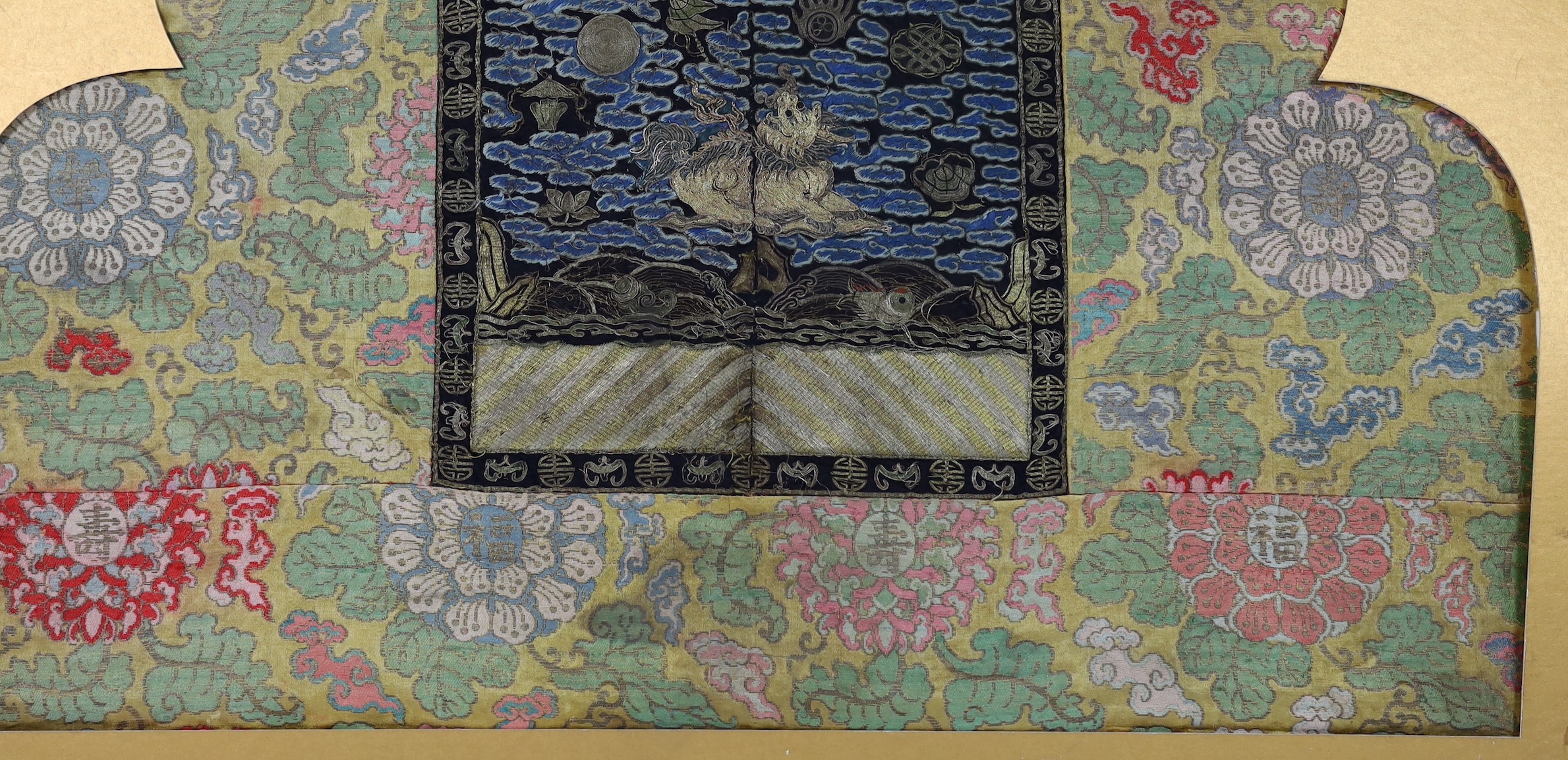 A 19th century Chinese embroidered silk military rank badge with 17th century silk brocade borders, total size 69.5cm x 83.5cm